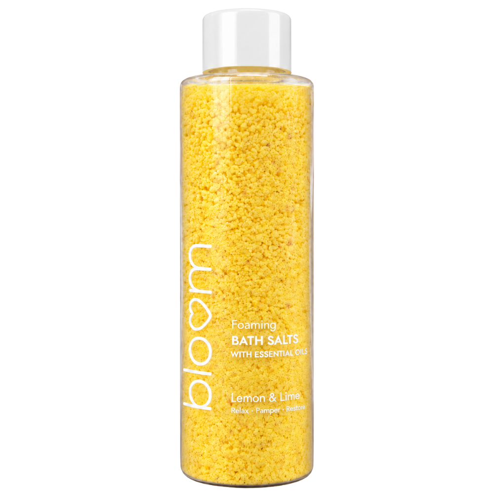 Bloom Lemon & Lime Foaming Bath Salts in a clear bottle with yellow salts and a white cap