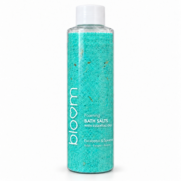 Bloom Eucalyptus and Spearmint Foaming Bath Salts in a clear bottle with turquoise salts and a white cap