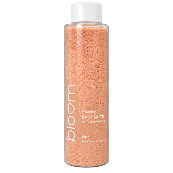 Bloom Jupe Foaming Bath Salts in a clear bottle with peach-coloured salts and a white cap