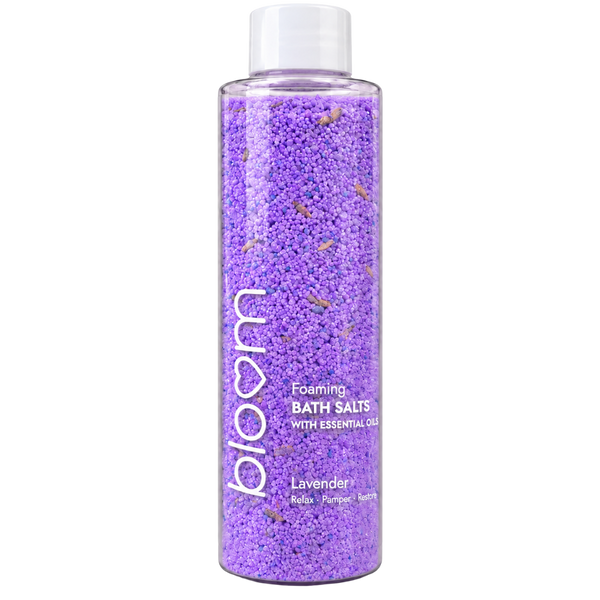 Bloom Lavender Foaming Bath Salts in a clear bottle with purple salts and a white cap