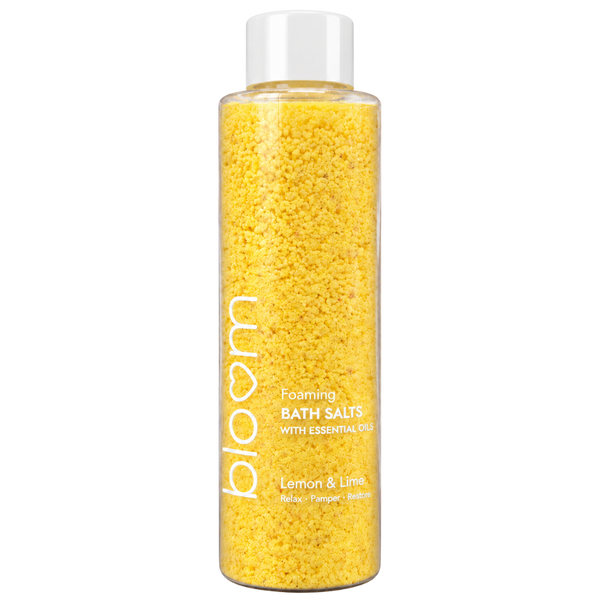Bloom Lemon & Lime Foaming Bath Salts in a clear bottle with yellow salts and a white cap