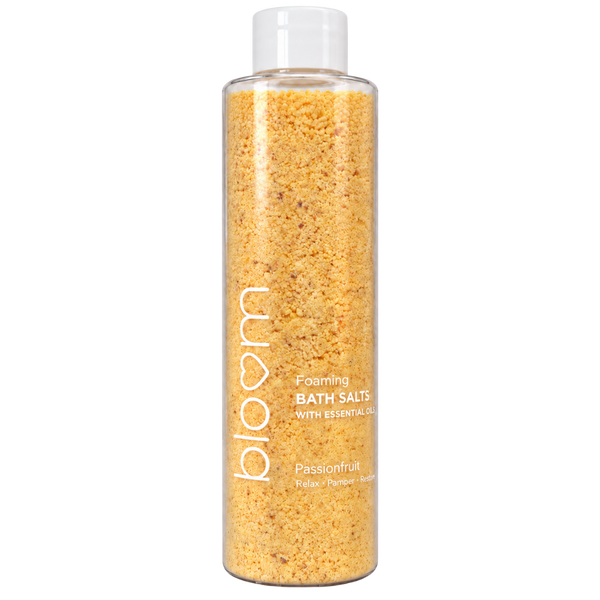 Bloom Passionfruit Foaming Bath Salts in a clear bottle with golden-yellow salts and a white cap